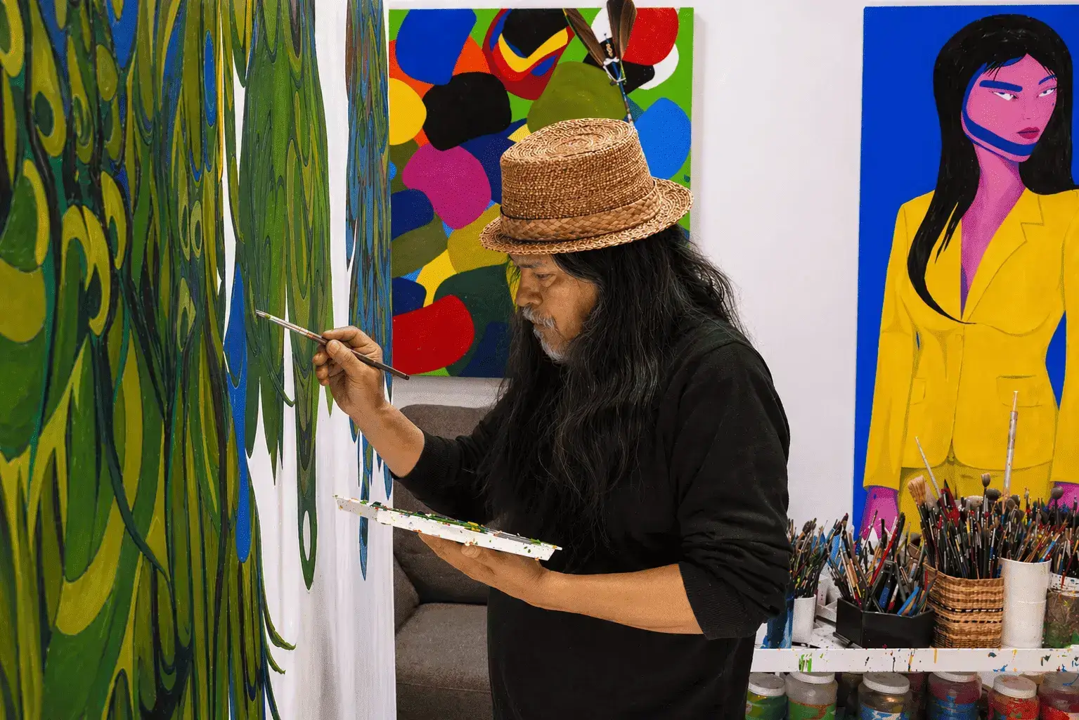 Artist Lawrence Paul Yuxweluptun is pictured in his studio painting provocative images in his artwork